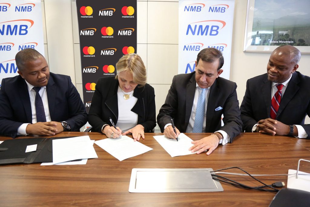 NMB Managing Director – Ineke Bussemaker signing a partnership agreement with Mastercard President for Middle East and Africa – Raghu Malhotra at a press signing ceremony held in Dar es Salaam today. The partnership will pave way for digitization of the agricultural sector in Tanzania with the rollout of eKilimo, a mobile solution developed by the Mastercard Lab for Financial Inclusion. Looking on the left is the NMB Acting Chief Retail Banking – Abdulmajid Nsekela and right is the Mastercard Division President Sub-Saharan Africa – Daniel Monehin.